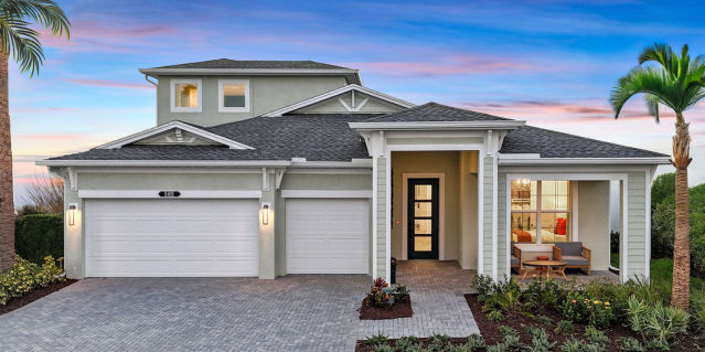 Exterior of a two story home with a 3-Car Garage with a sunset in the background