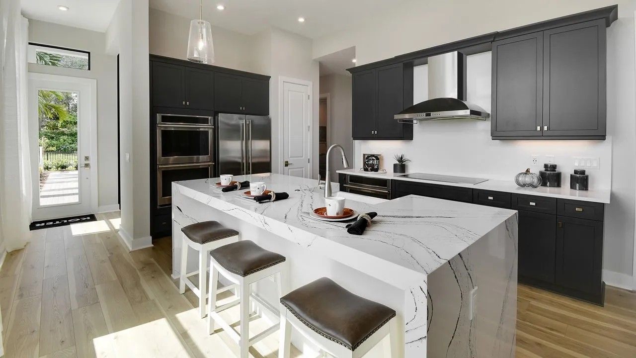 Designer-decorated kitchen and open living space inside a Rivella model home