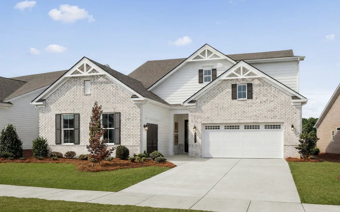 Whitewashed brick home with white gable trim, black shutters and a two-car garage
