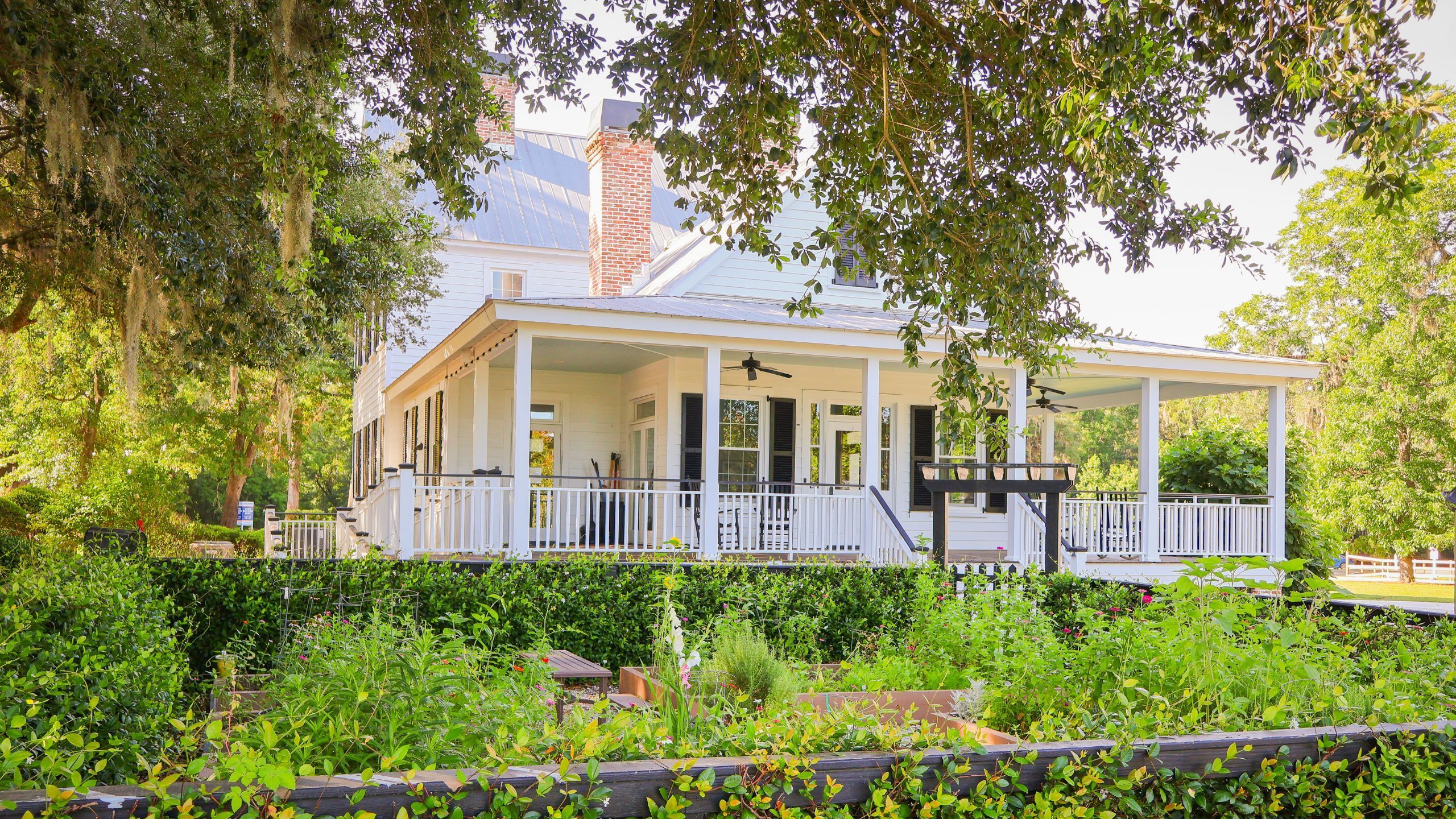 The Farmhouse at The Ponds with wraparound porch and rocking chairs