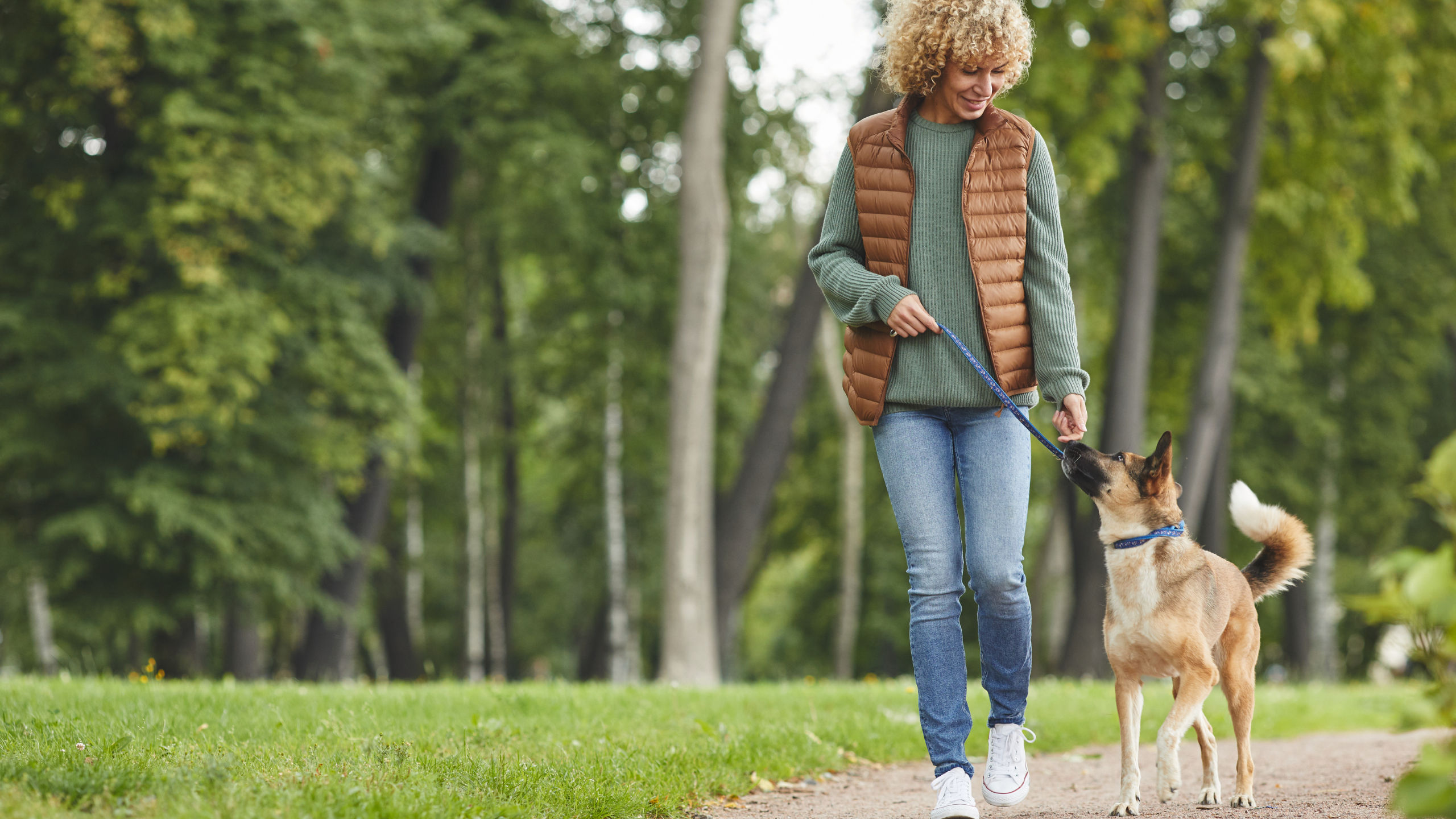 woman walking dog on trail at The Ponds