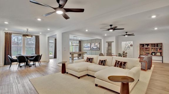 Spacious living space, dining area, and game room with expansive windows and doors. | Daylight Basement